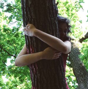 Baum_umarmen_Judith_Barfuss_Achtsamkeit_Entspannung Eine junge Frau umarmt einen Baumstamm.